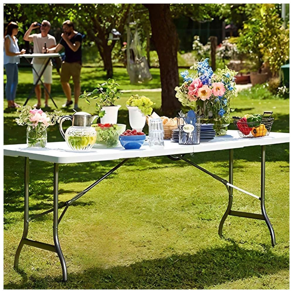 White 6 ft buffet table set with food, drinks, and flowers at a backyard party — no kids chairs